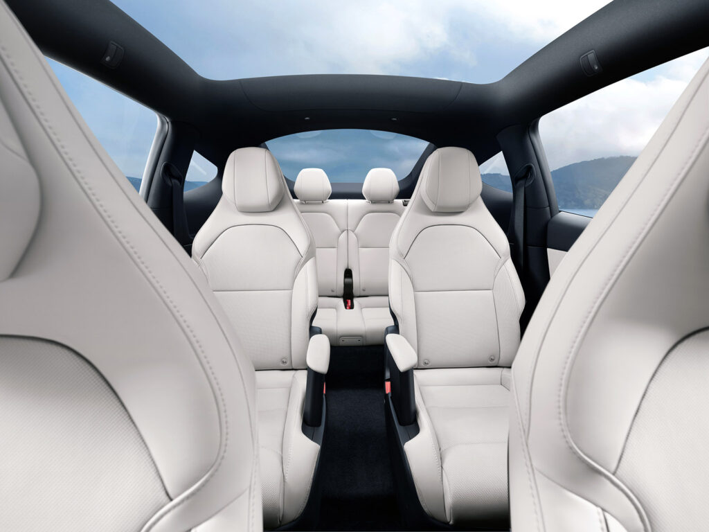 Asientos traseros tipo capitán plegados completamente planos en el interior del SUV familiar de Tesla Model Y L.
